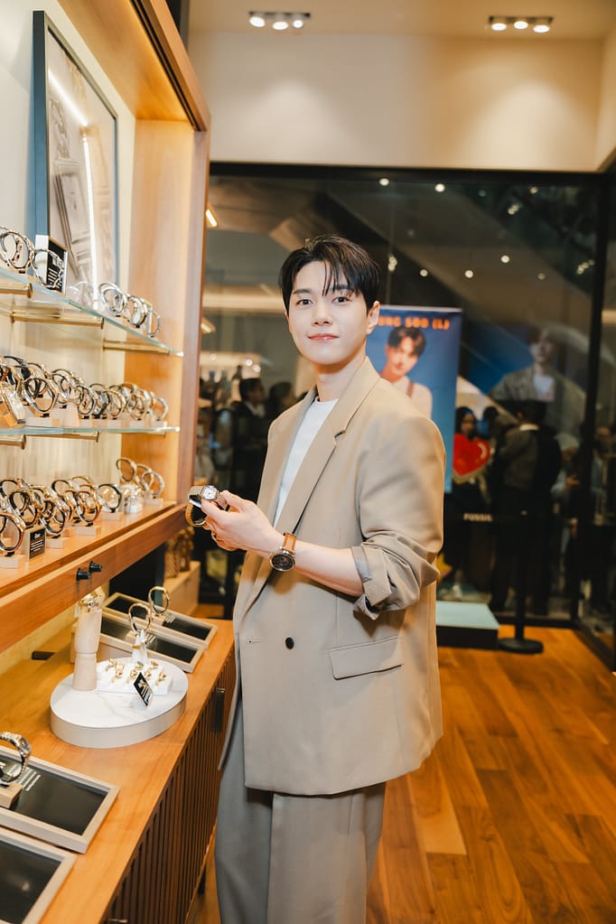 Kim Myung Soo (L) holding the Harlow Three-Hand Stainless Steel Watch (ES5363) and wearing the Townsman Automatic Brown Leather Watch (ME3110)